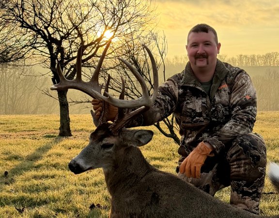 An Ohio hunter kneels next to a 13-point buck.