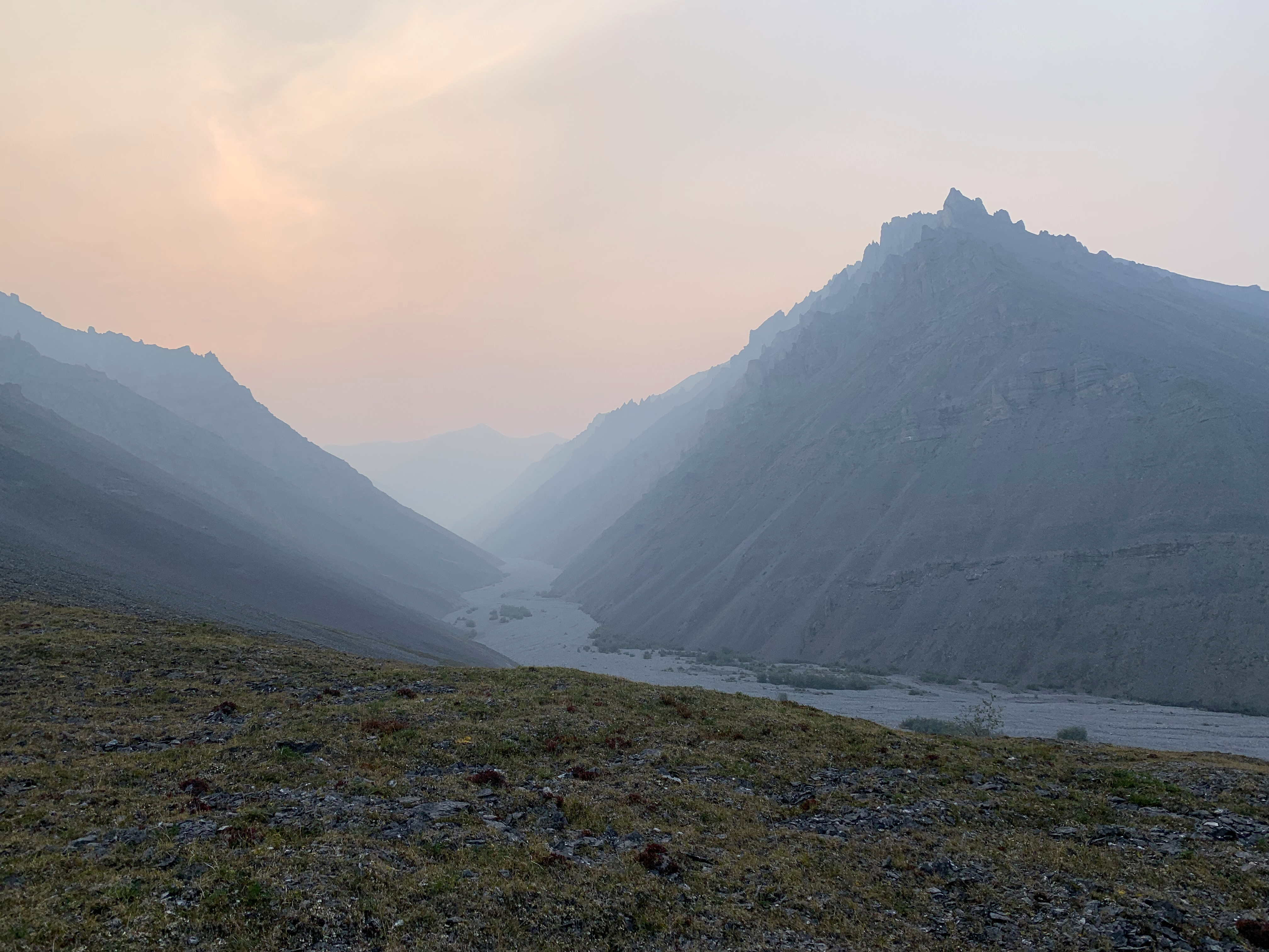 A haze of smoke drifts through the mountains of Alaska.