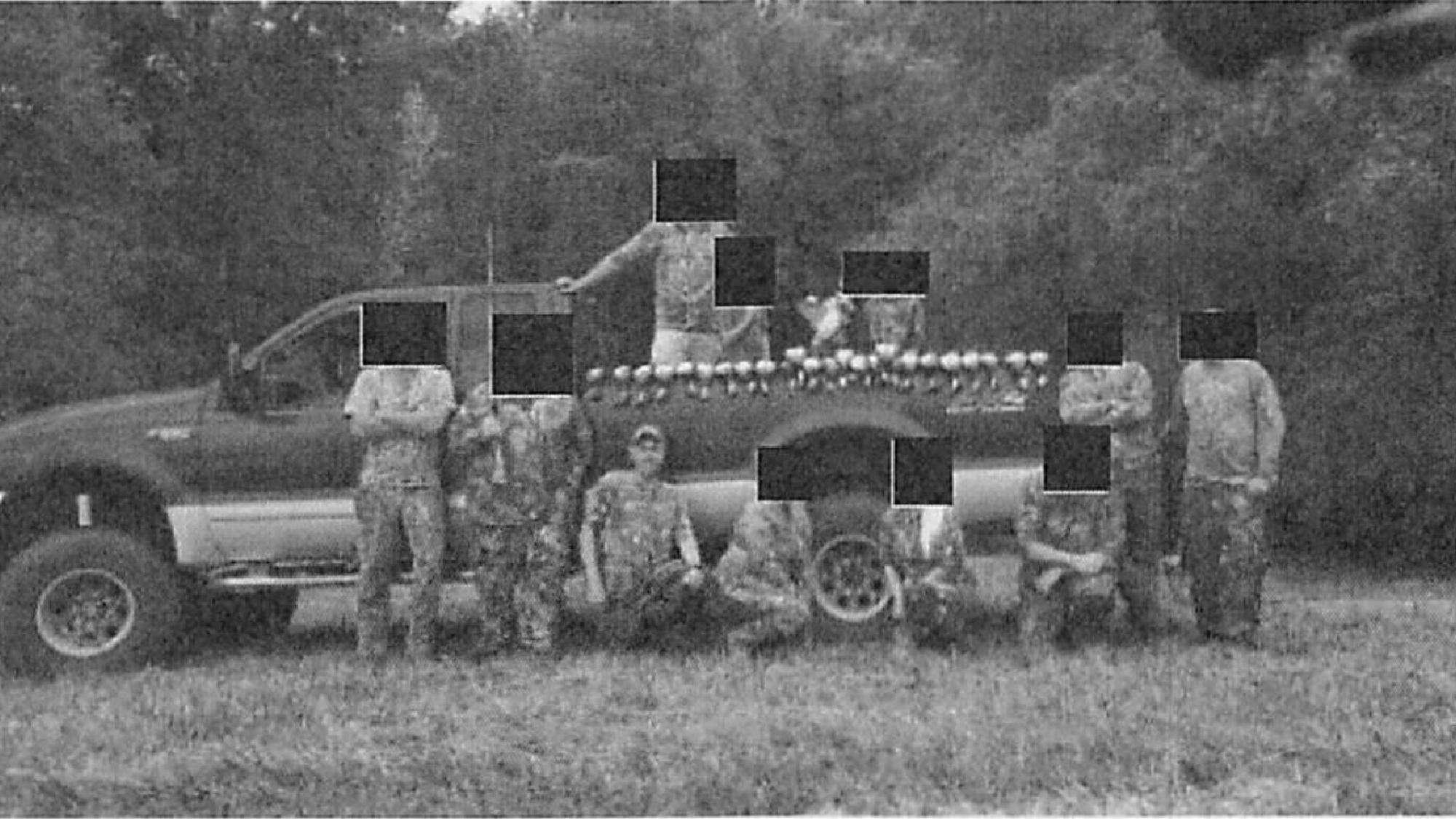 poachers with redacted faces pose with a pile of wood ducks