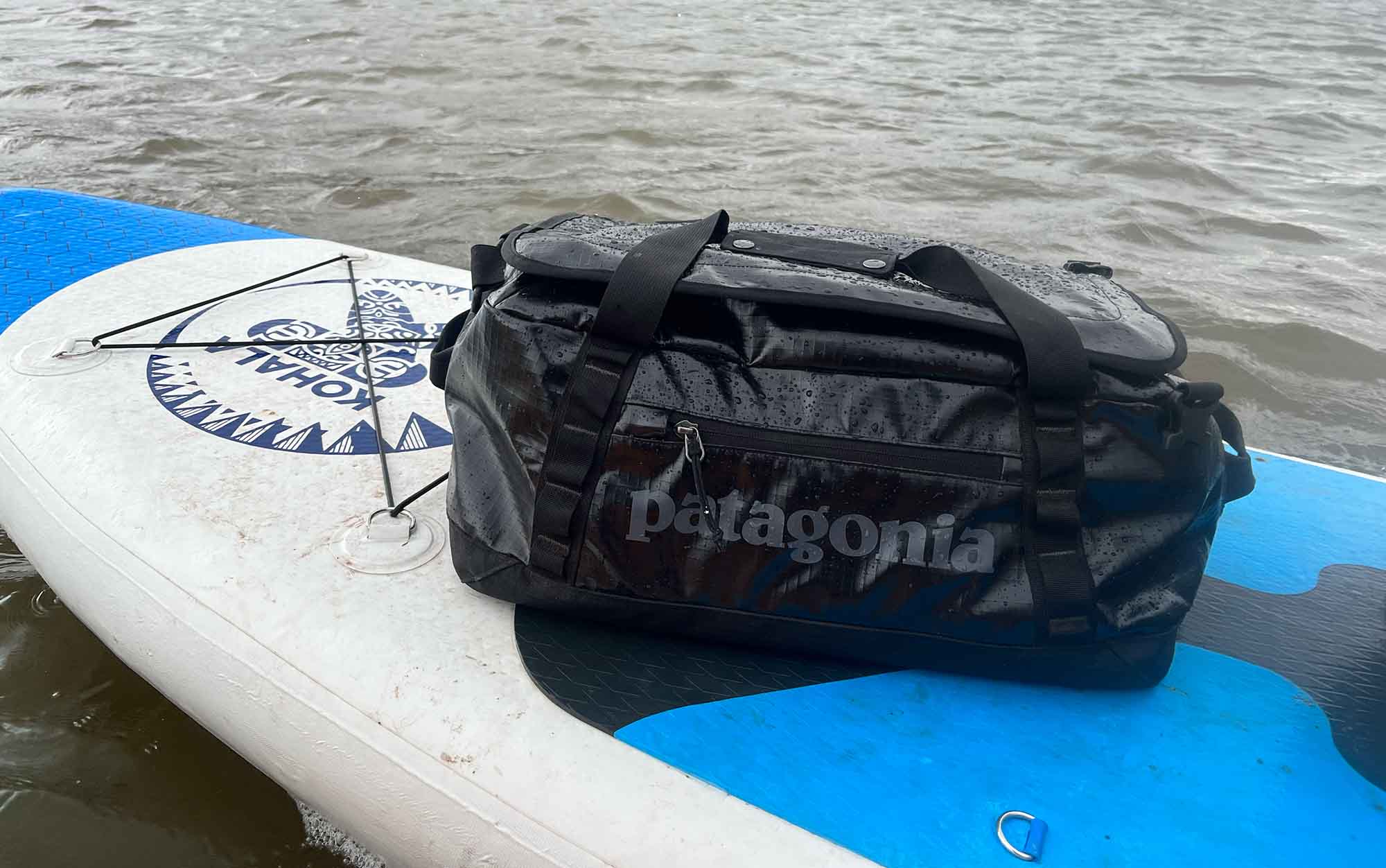 The Black Hole duffle sits on a paddleboard.