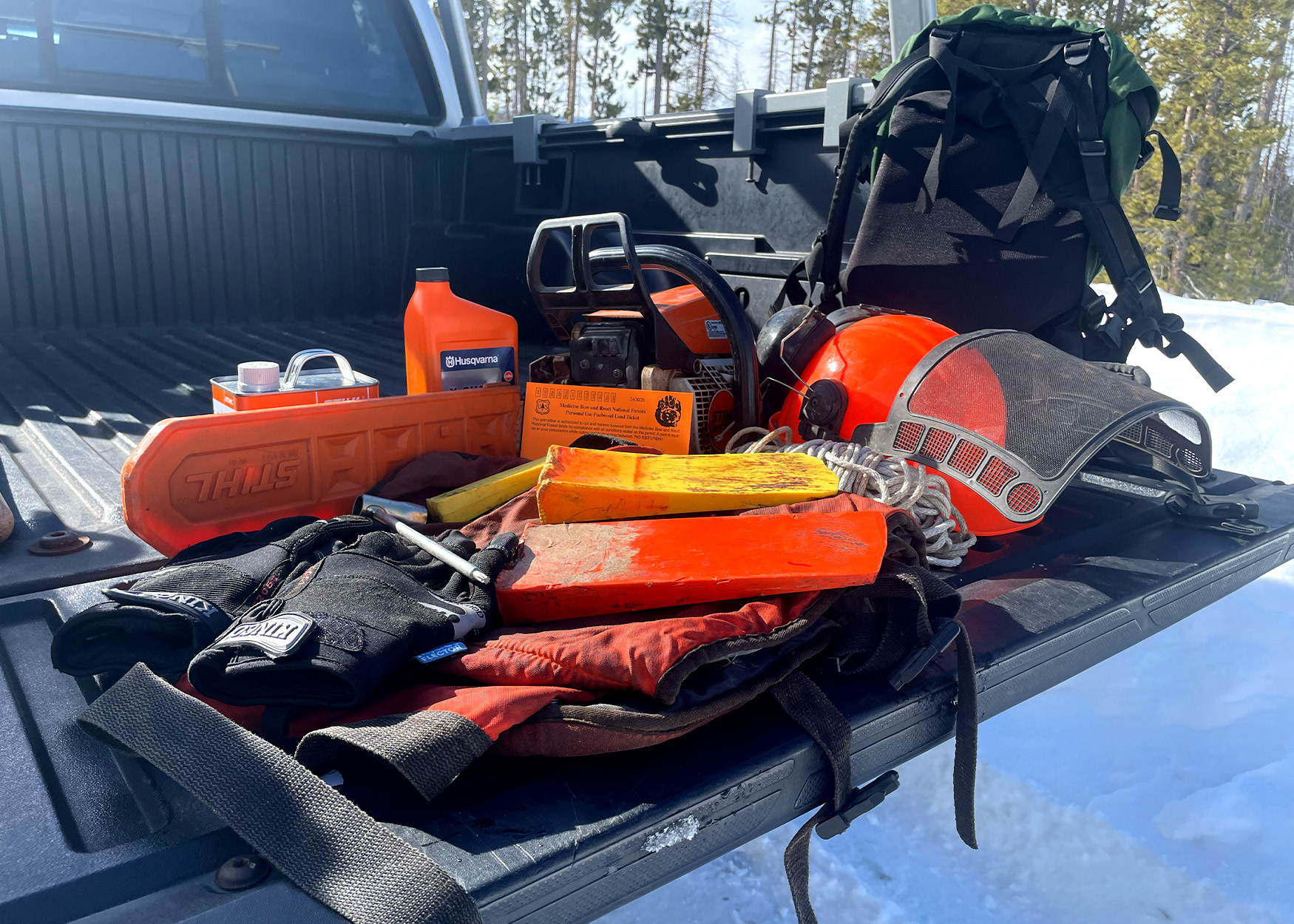 Chainsaw with other tools in a truck bed.