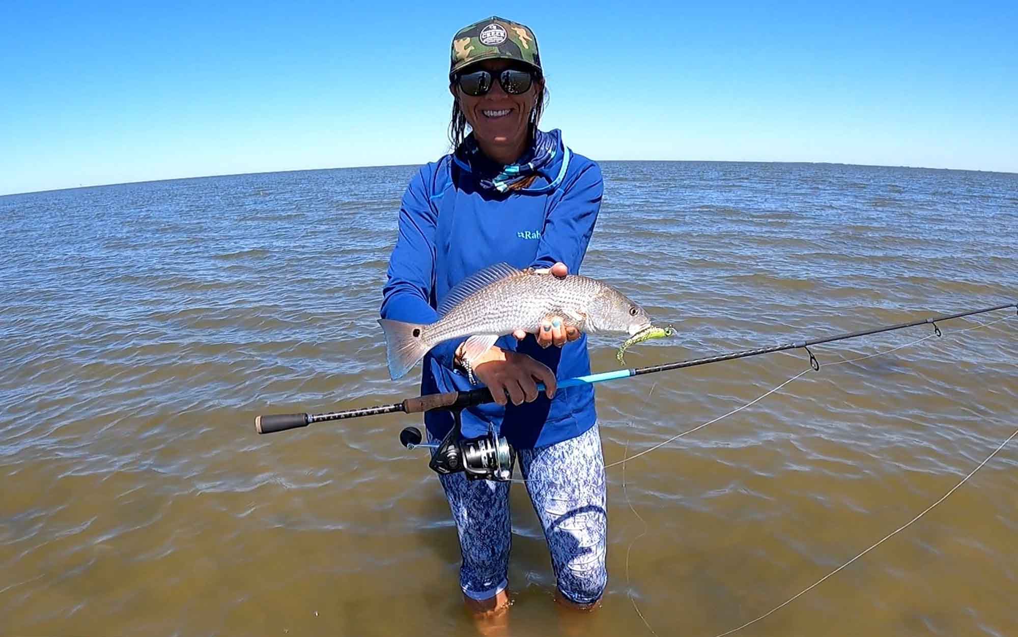 Angler holds fish and Shimano inshore fishing rod.