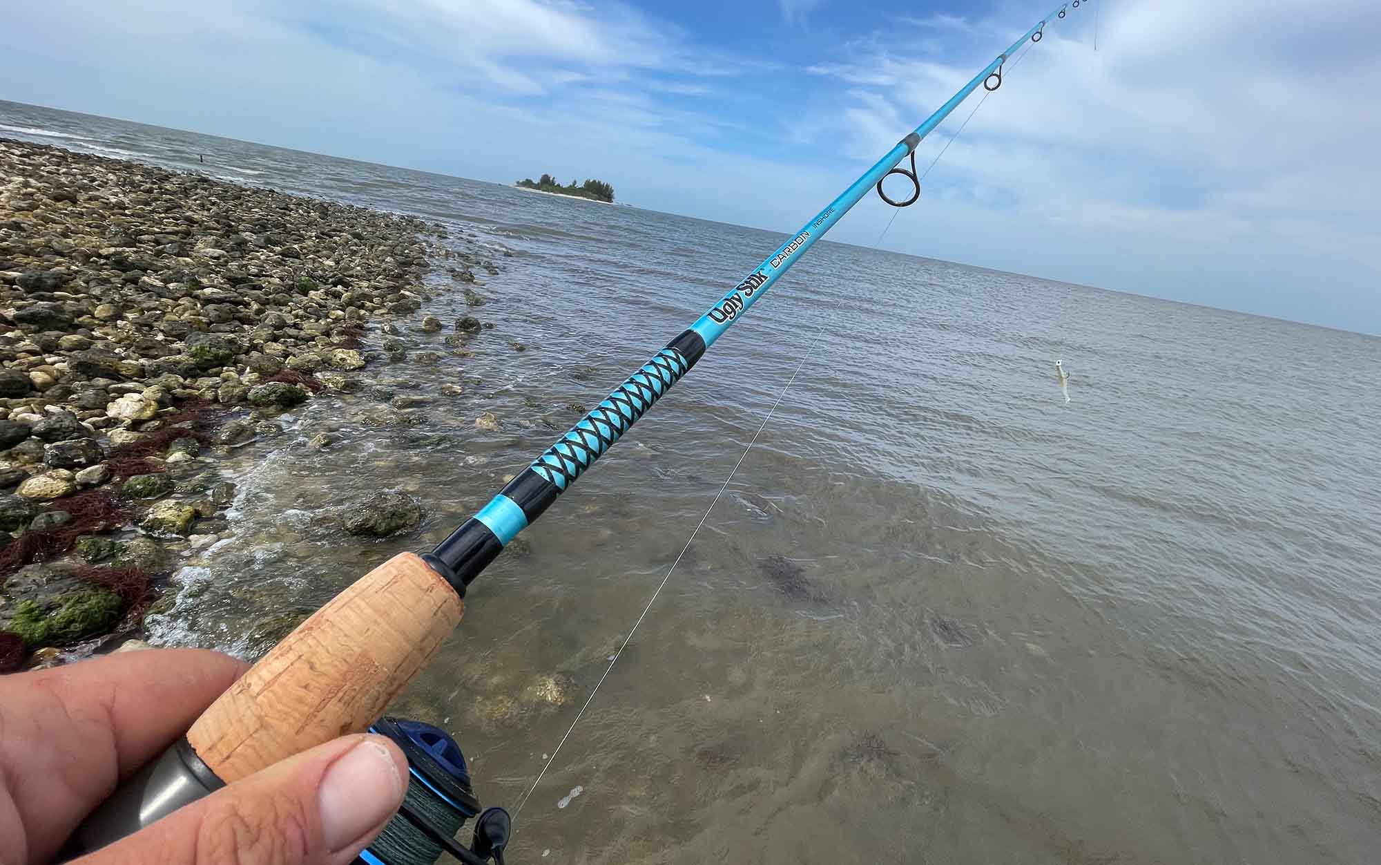 Author holds the Ugly Stick Carbon on a rocky shore.