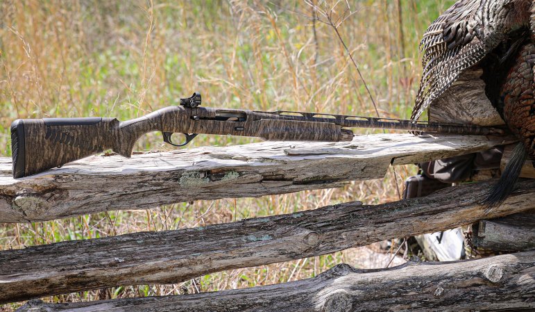 The Benelli M2 Turkey Performance Shop shotgun resting on a split rail fence.