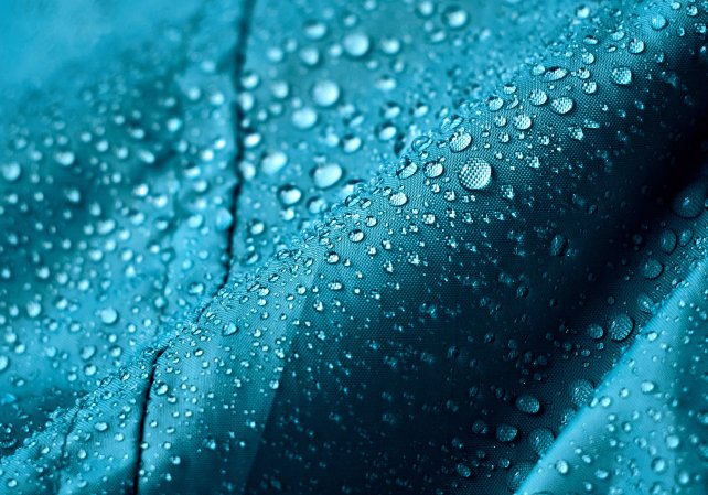 Rain water droplets on blue green waterproof fabric