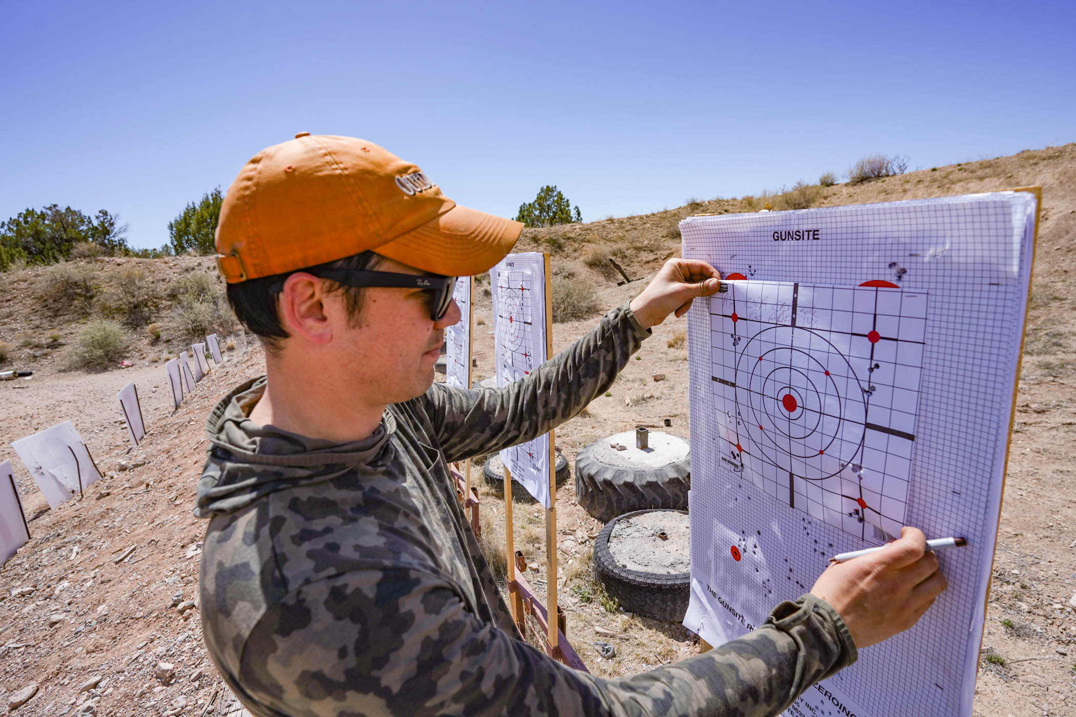 A tester inspects rifle accuracy results.