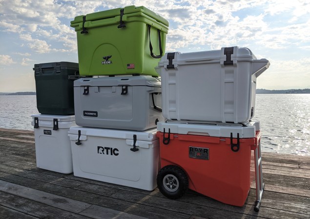 Seven coolers stacked on a dock.