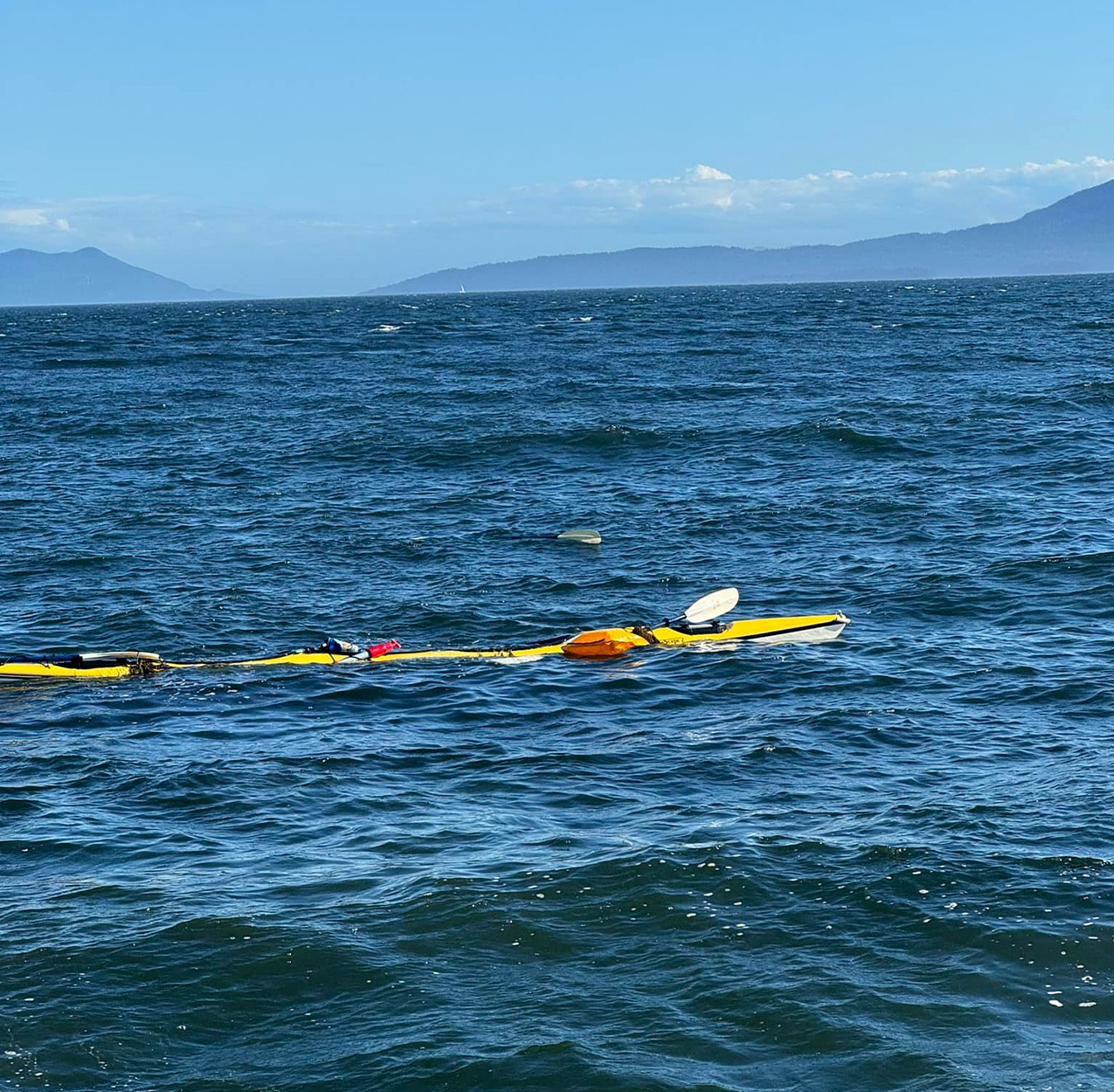 An empty sea kayak floating in the bay.