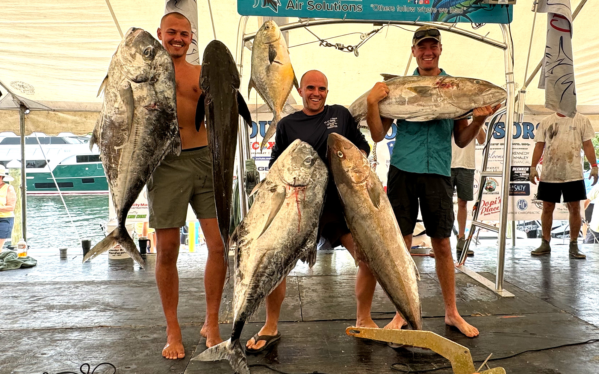 Spearfishermen hold up their catches.