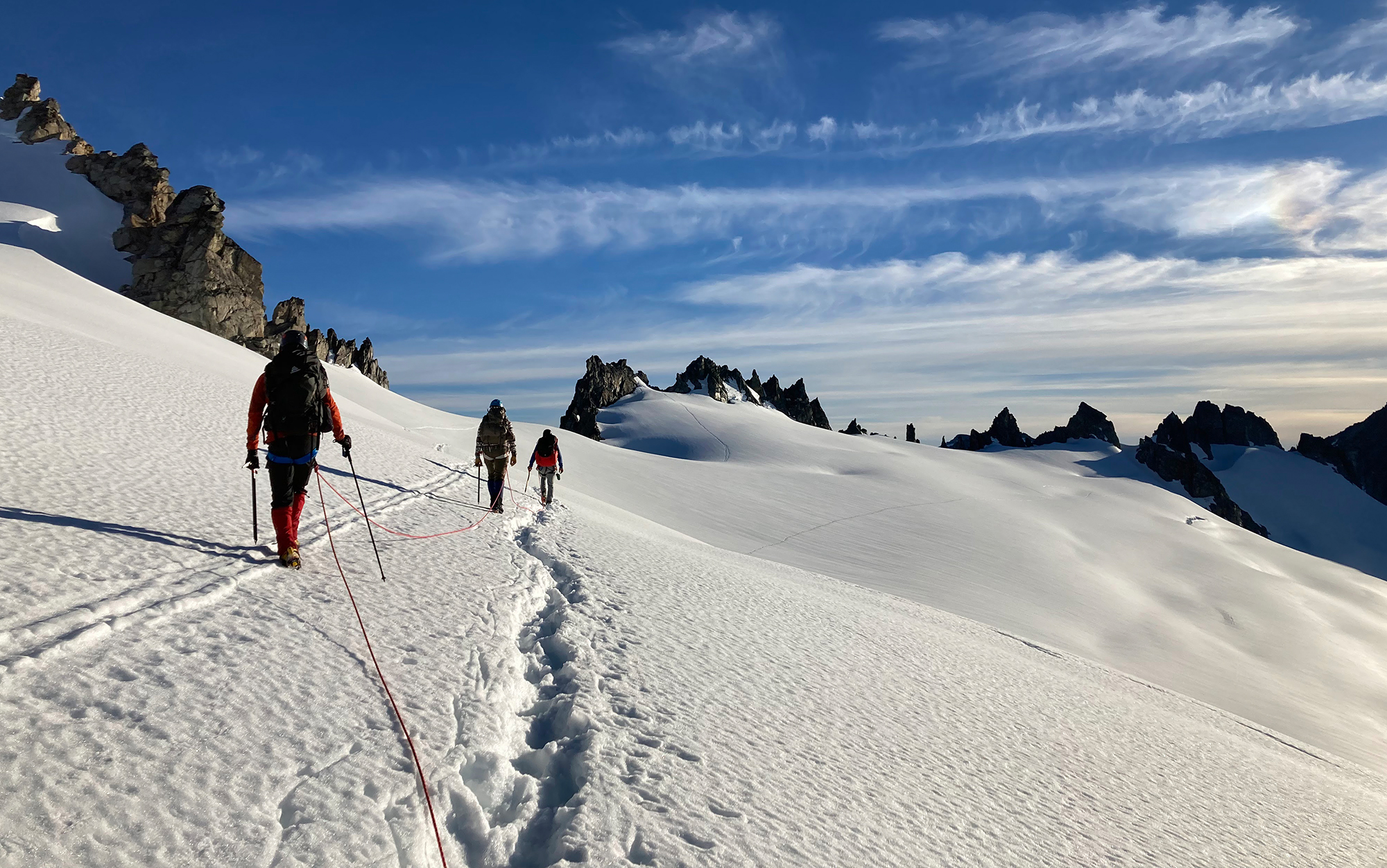 Mountaineers walk across snow.