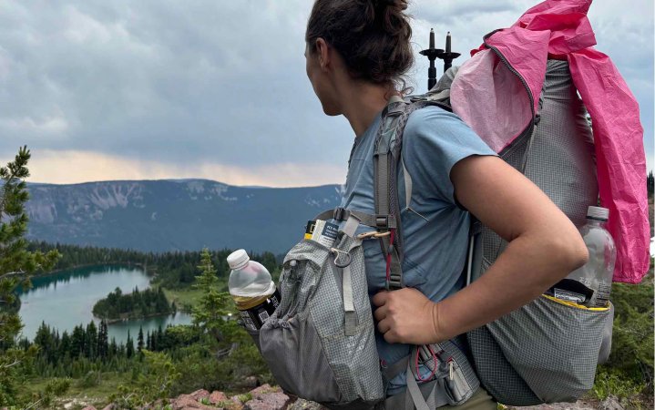  woman looking out at mountain ridge while wearing the Aarn Mountain Magic Pro backpack