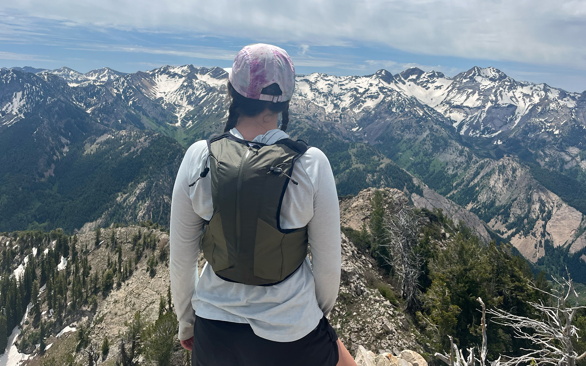 Runner stands on summit in Senja running vest.