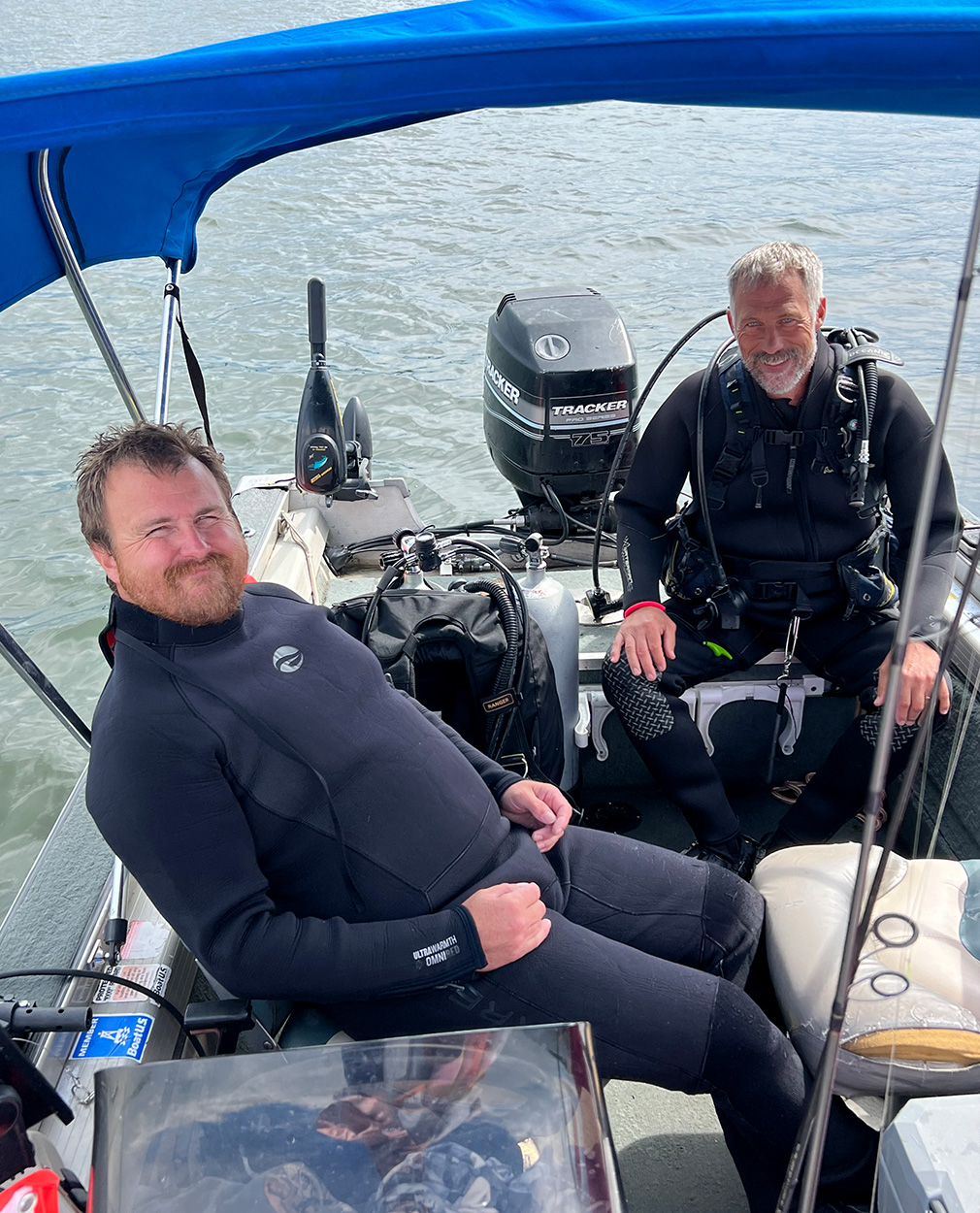 Two scuba divers on a boat.