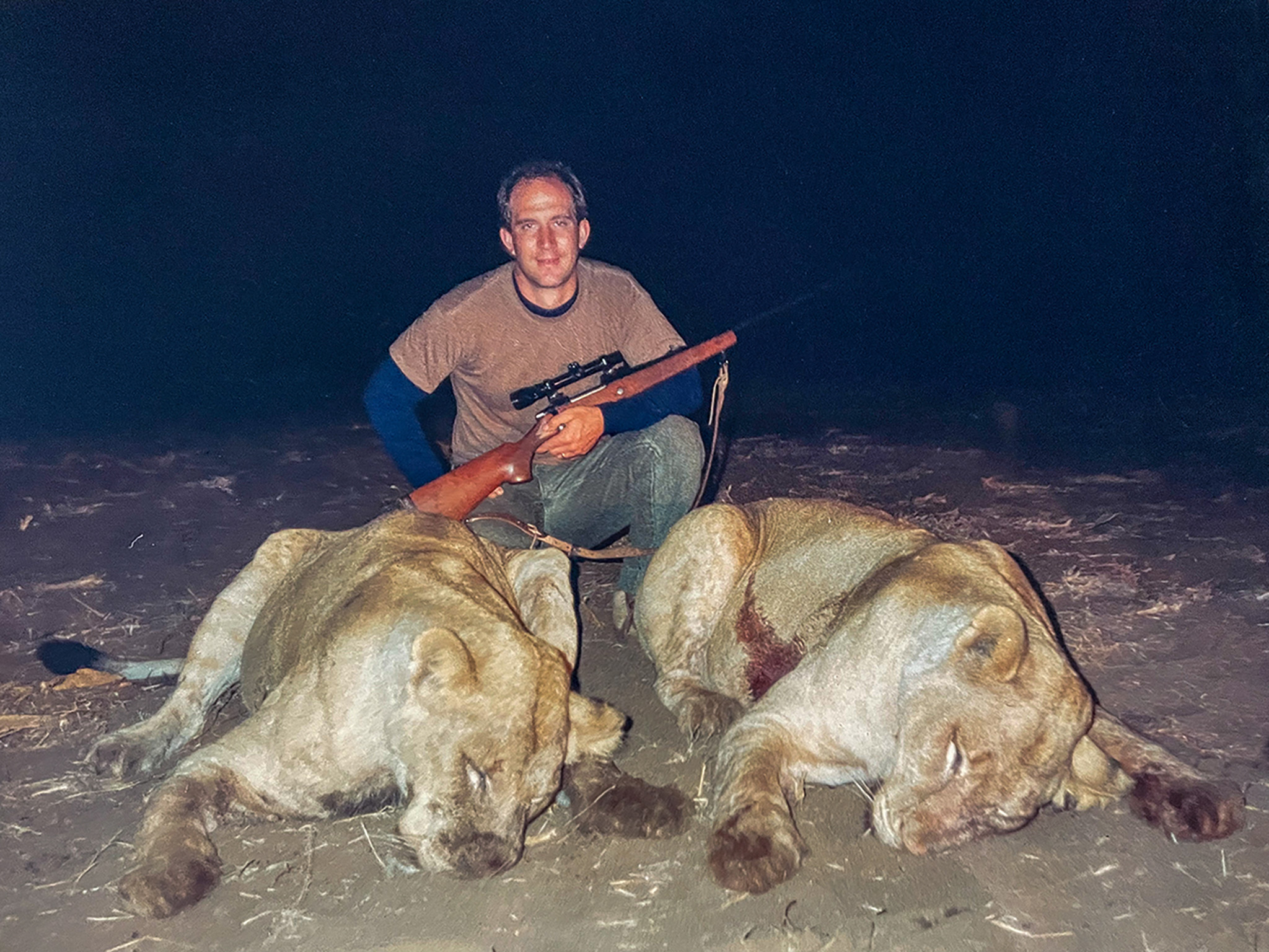 Scott Haugen kneels beside two man-eating African lions.