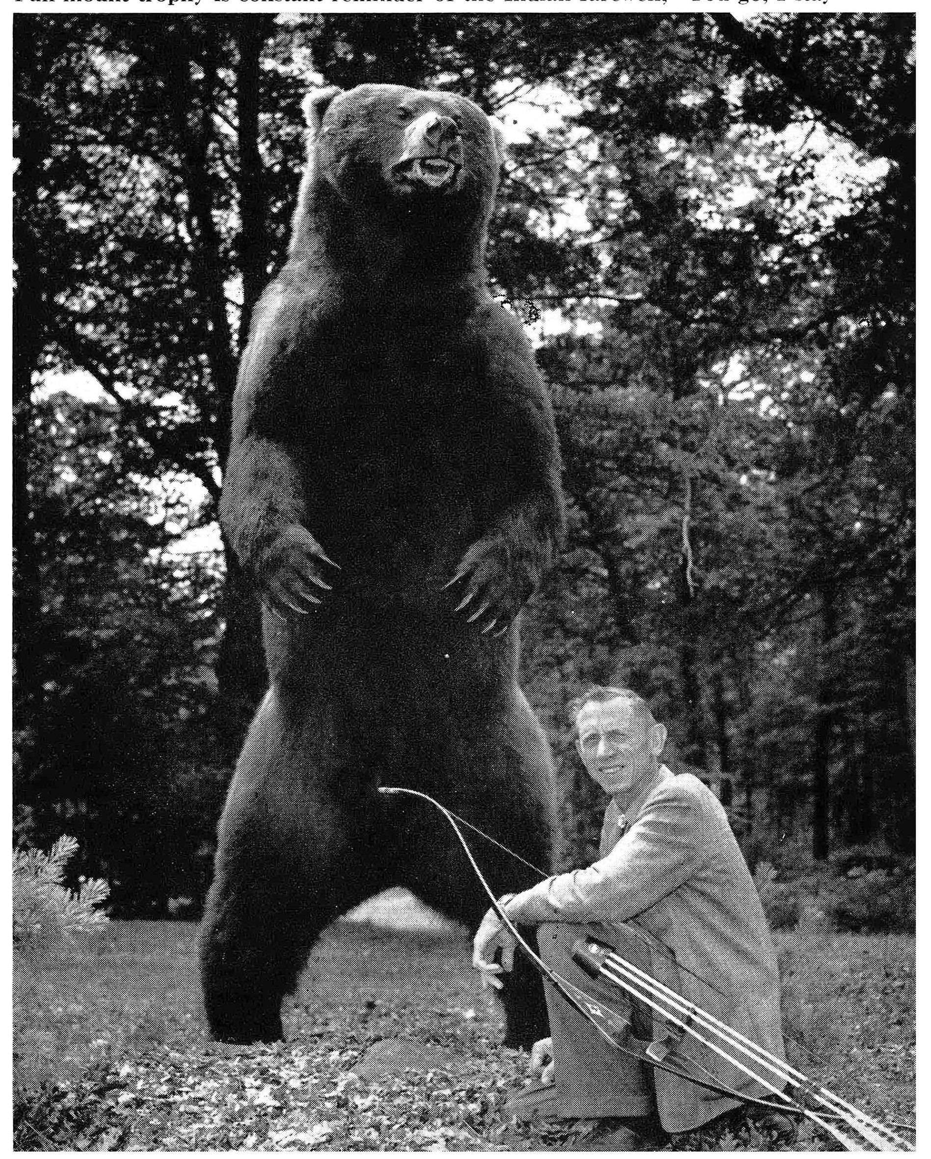 Fred Bear beside a standing full body mount of a brown bear.