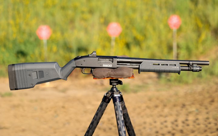  The Mossberg 590S pump action shotgun resting on a tripod at the range.