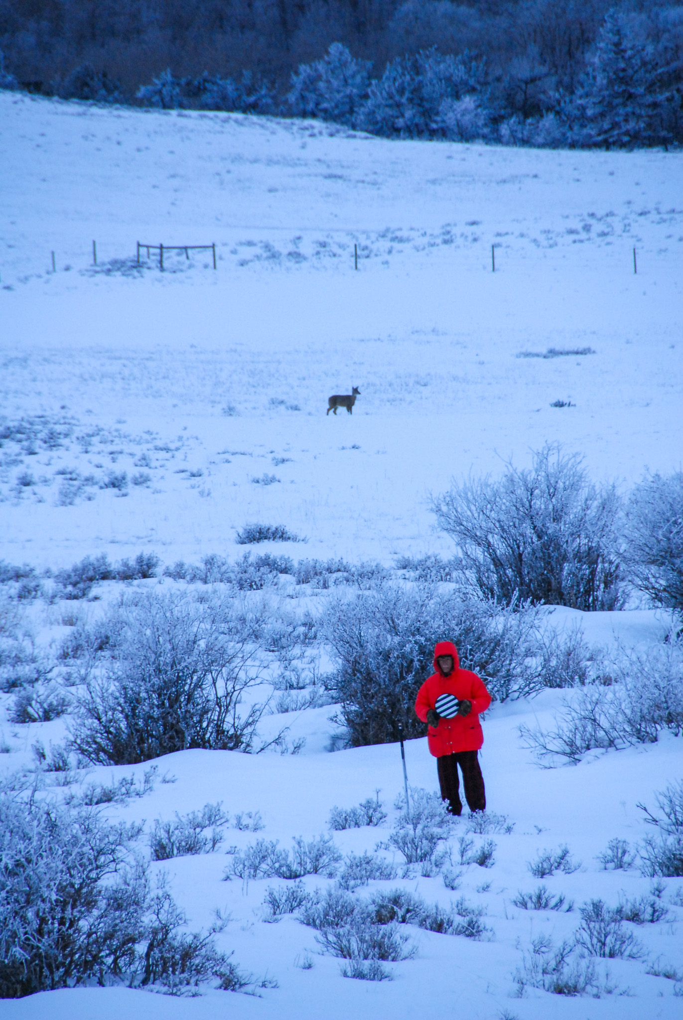 A man in an orange puffy coat turns a resolution wheel used to test optics.