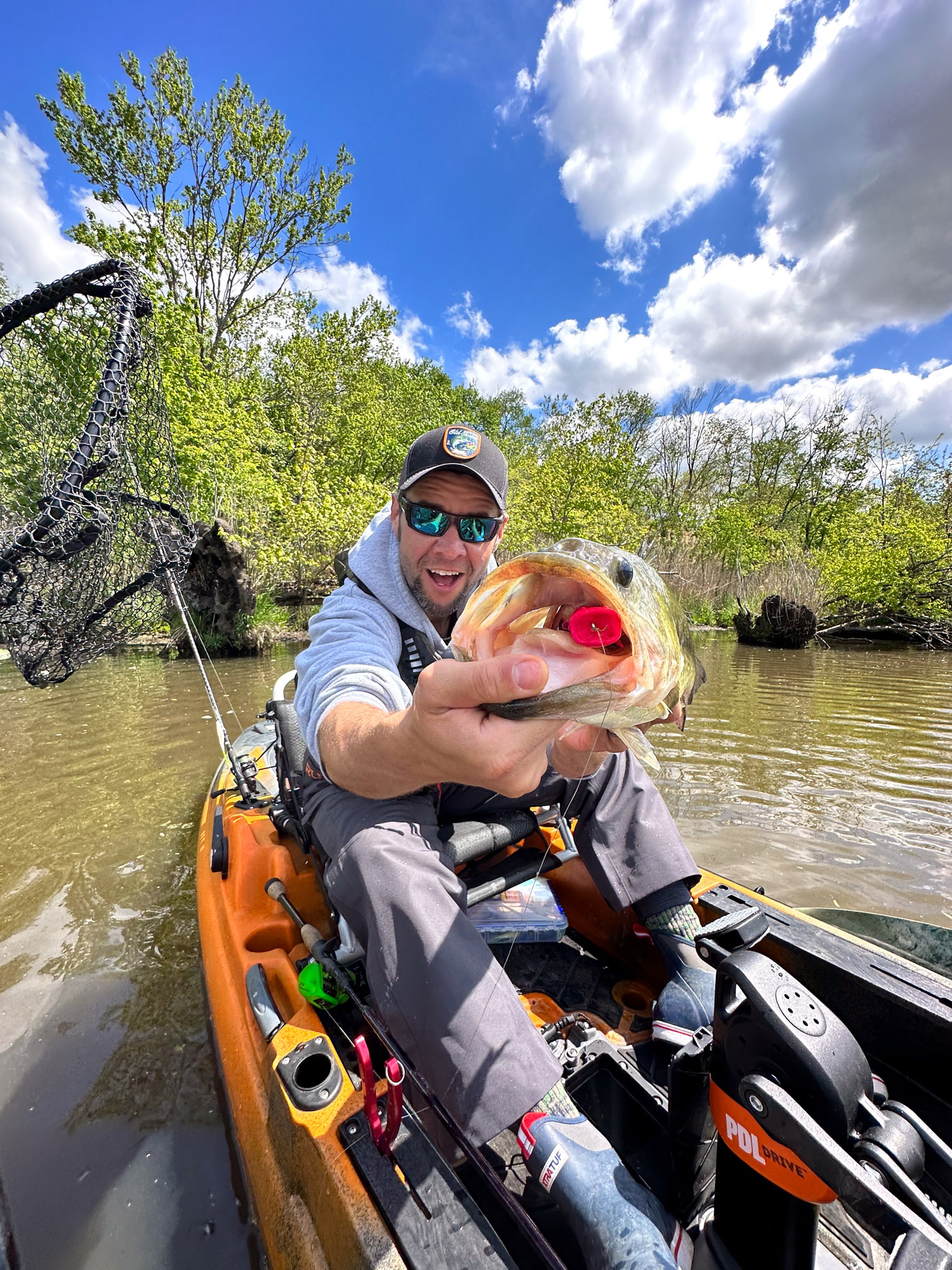 A kayak fisherman with a bass