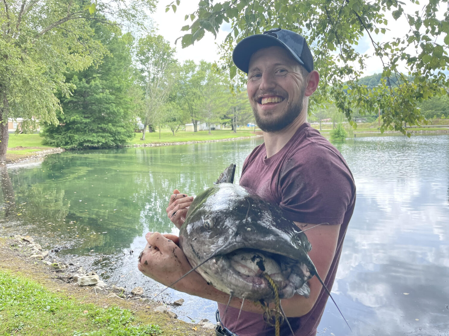 Smiling man holds giant catfish.