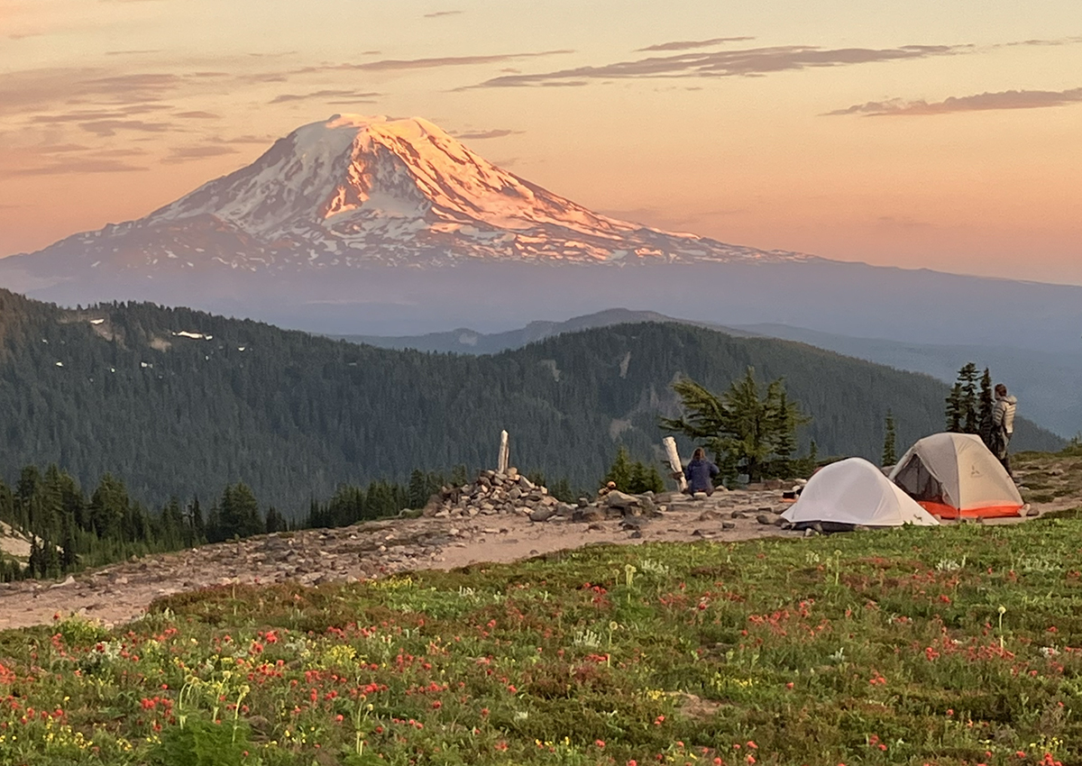 two backpacking tents against a mountain backdrop at golden hour