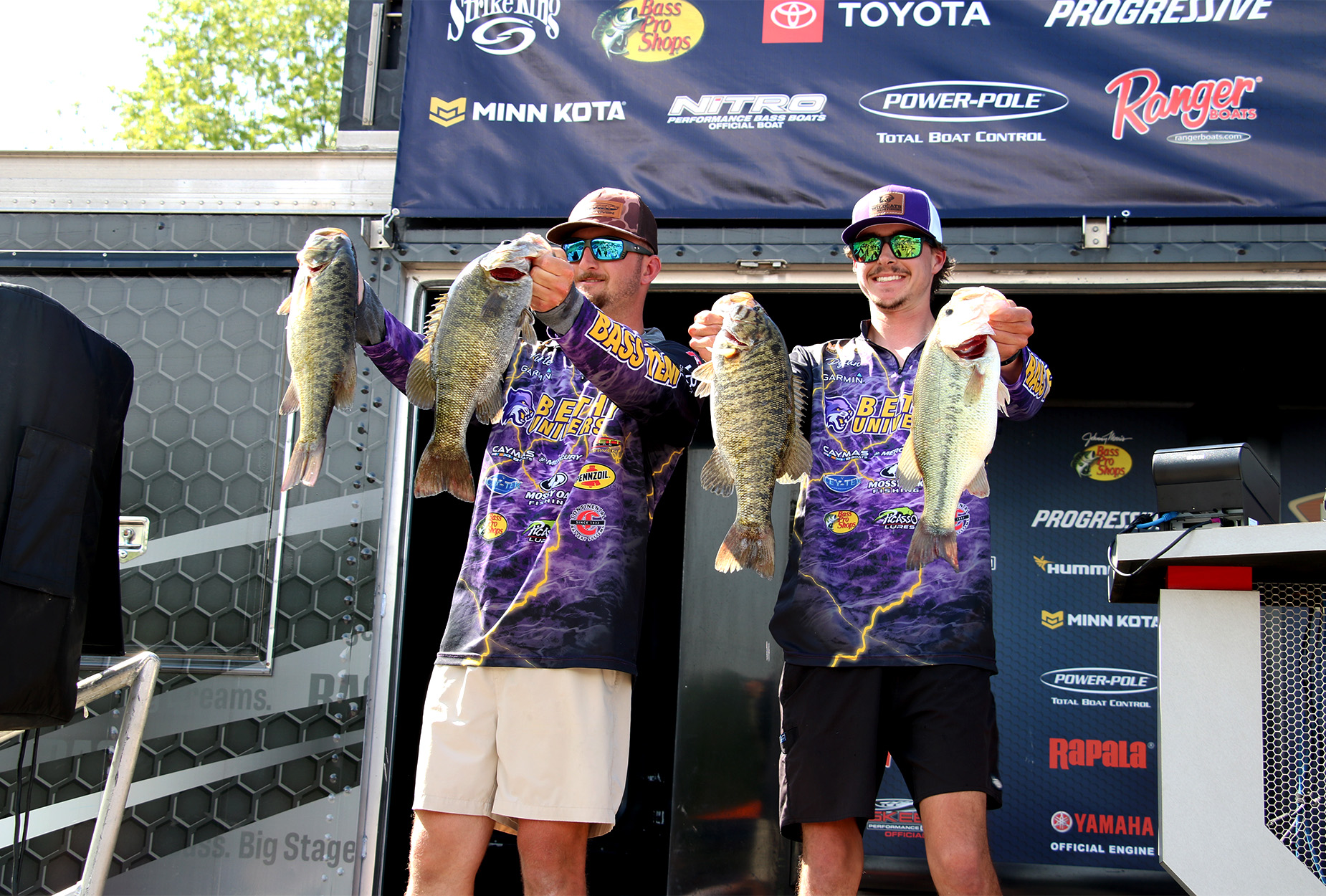 Two Bethel University anglers hold up bass.