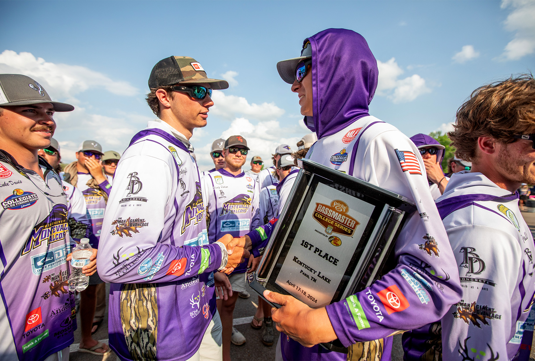 Two college fishing competitors shake hands.