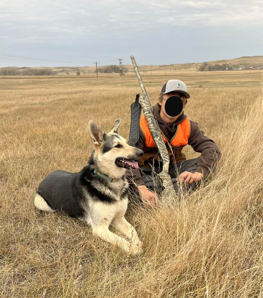 A hunter poses with his german shepherd that was killed by a neighbor.