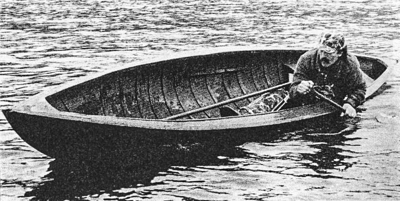 A duck hunter leans to the side in a rollover boat in an old black and white photograph.