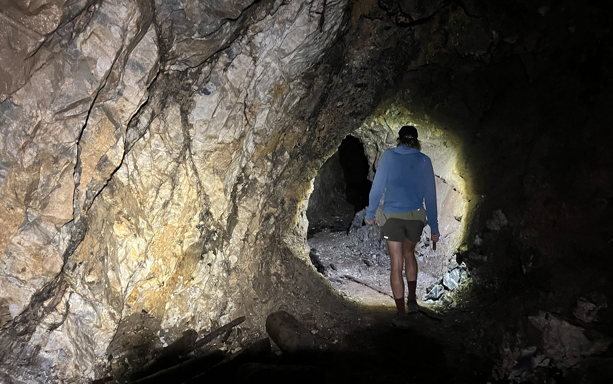 Man walks through a dark cave.