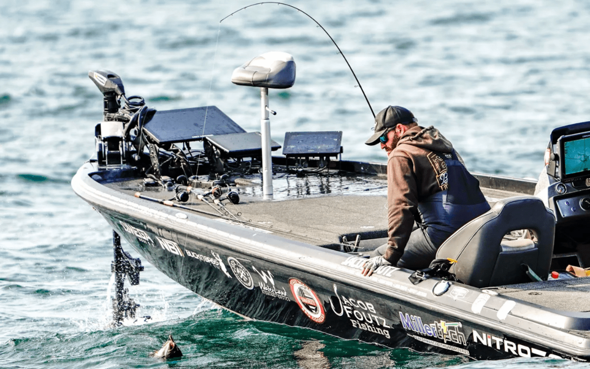 professional bass angler on a boat catching a fish