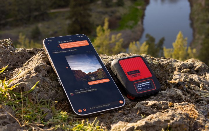 A phone and the Garmin inReach Messenger Plus sit on a rock.