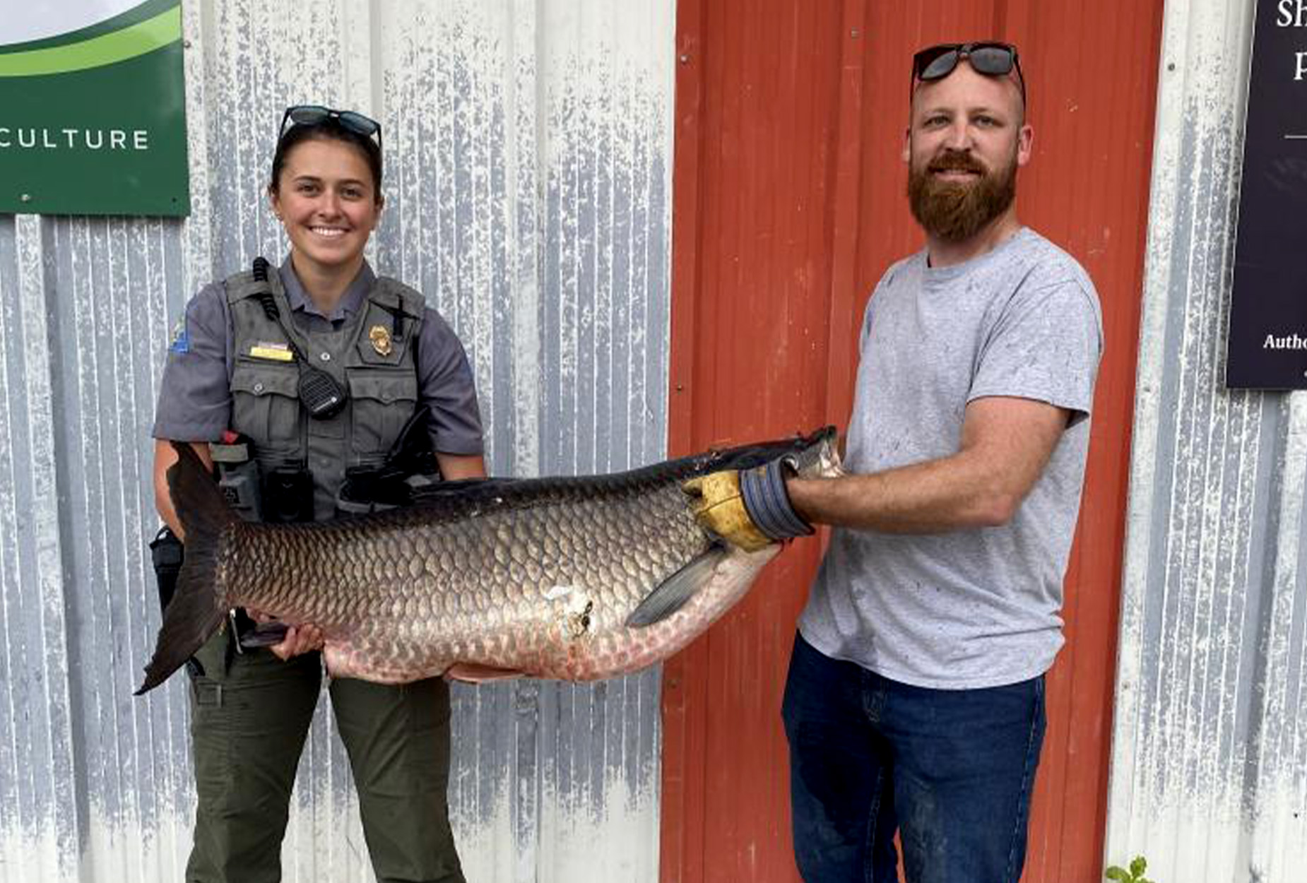 A Missouri bowfisherman and a state conservation agent hold up a record carp.