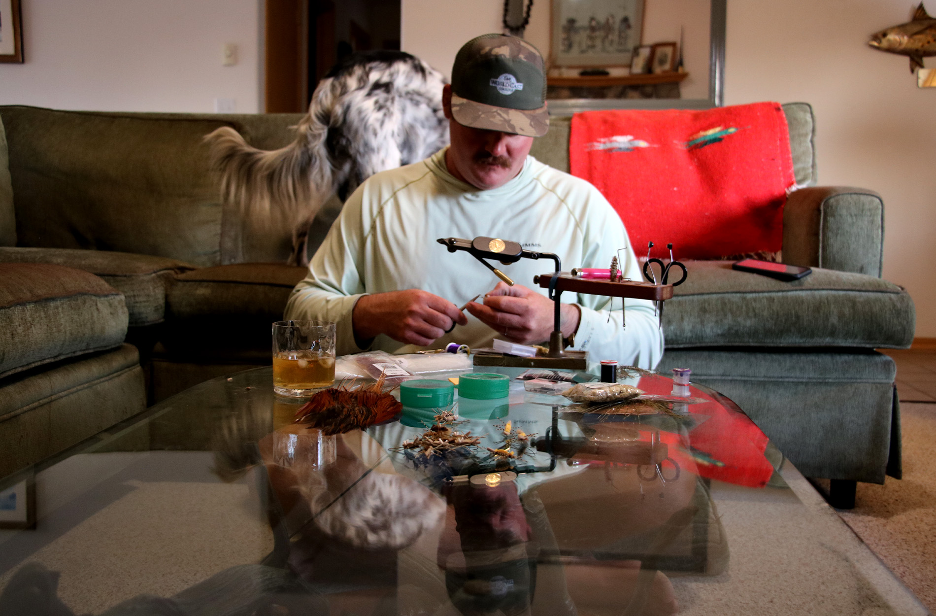 A fly fishing guide ties a fly in his living room.