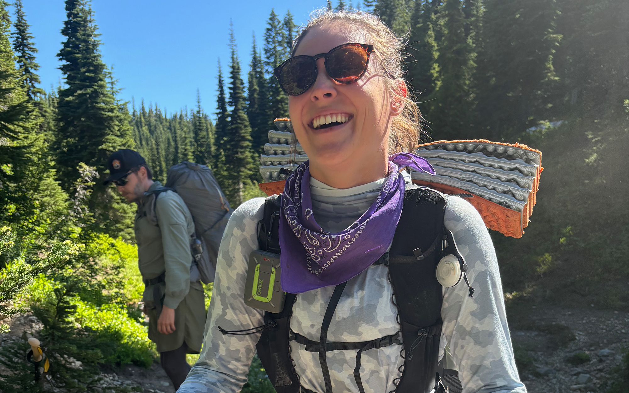 Hiker wears Zoleo clipped to the strap of her backpack.