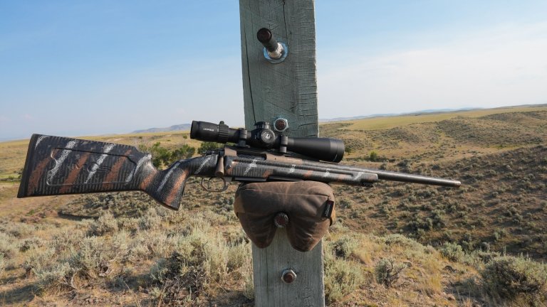 Mack Brothers Custom Rifle 6.5 Creedmoor rests on a shooting bag on a post on the range.