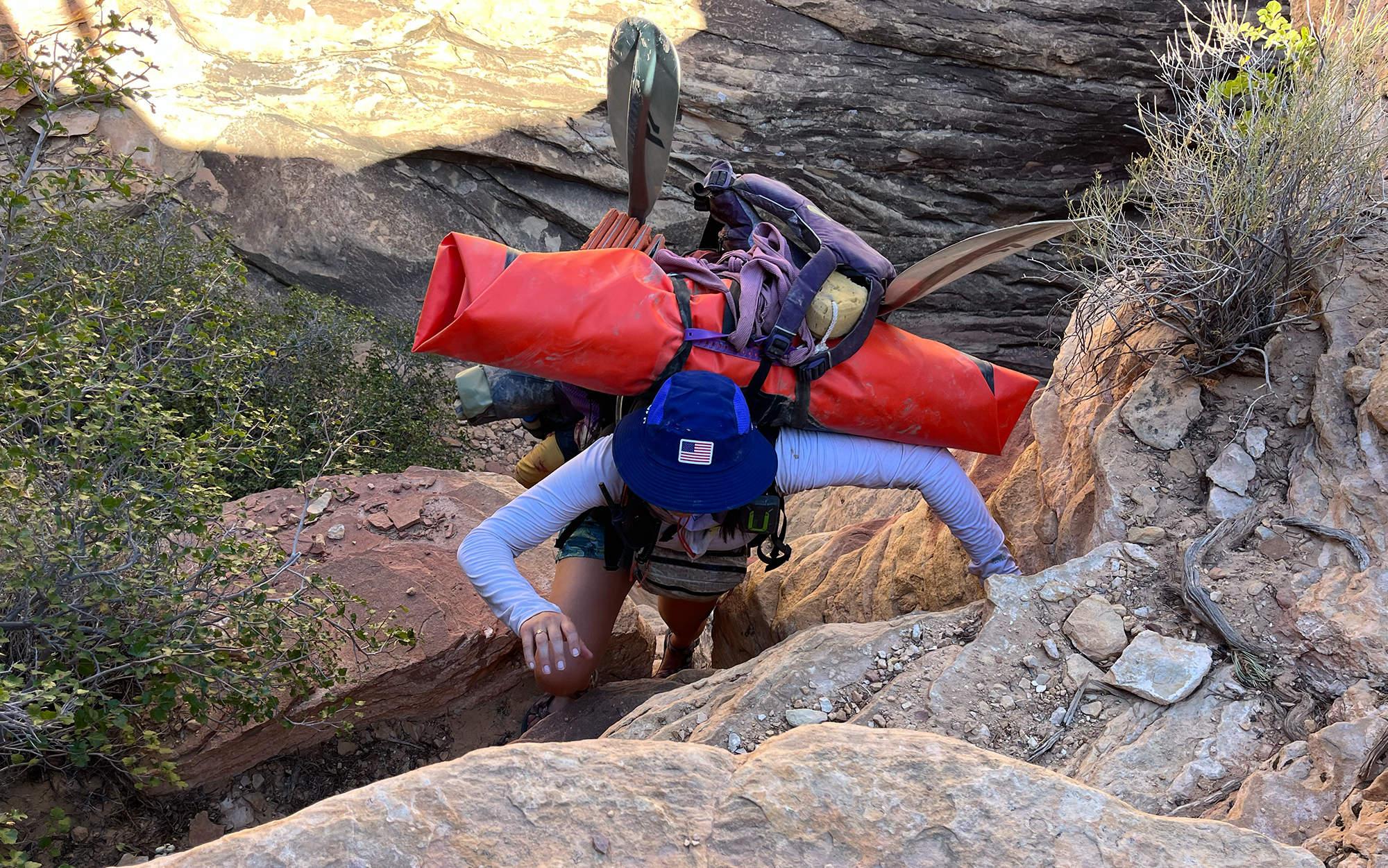 Author climbs up rocks in one of the best sun hats.