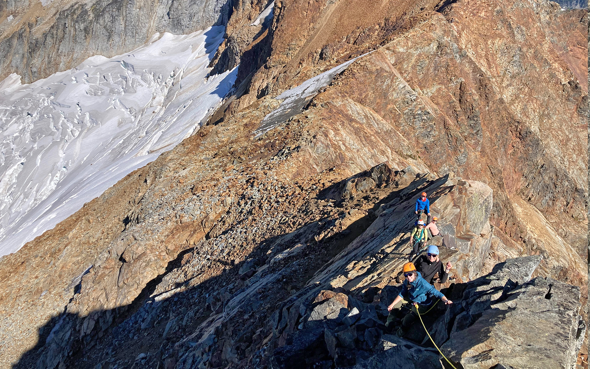 Climbers summit rocky ridge.