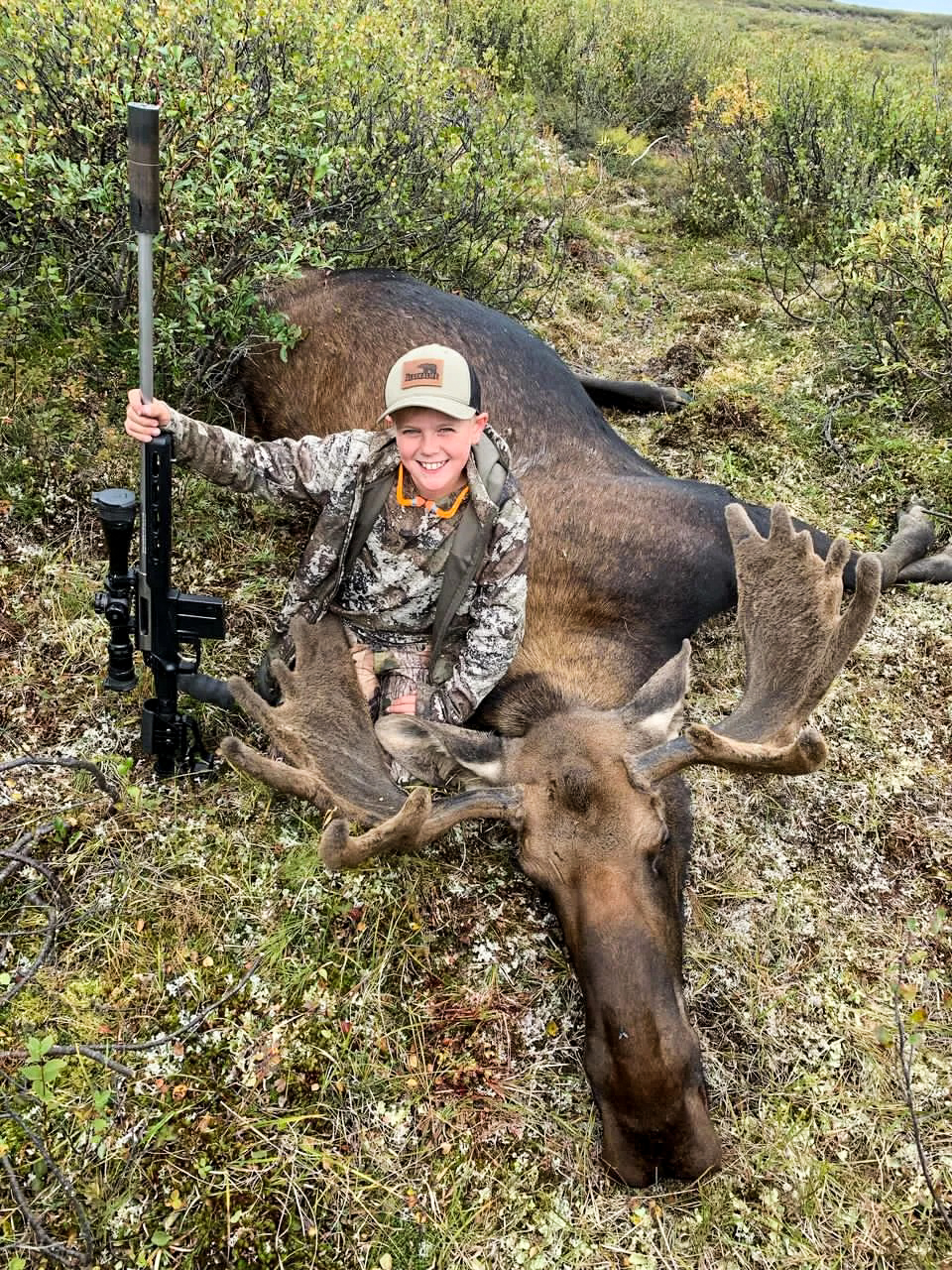 A kid with a bull moose in Alaska.