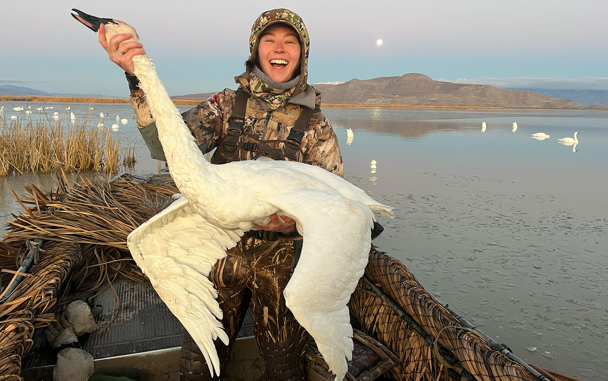 Author holds tundra swan on a boat.