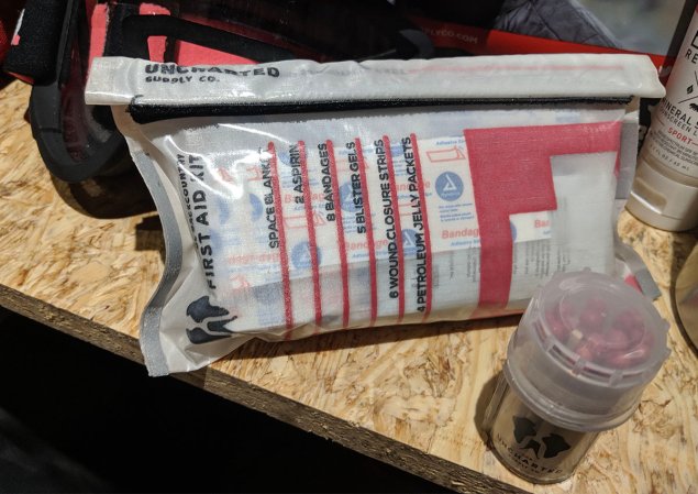 emergency first aid kit and matches on a bare wood plank