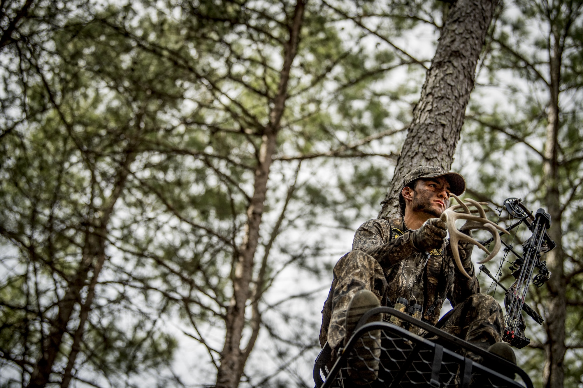 A bowhunter rattles to deer.