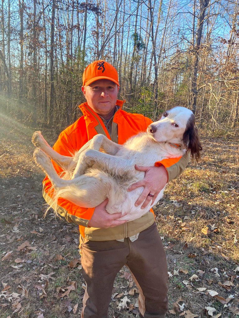 A hunter holds a setter that he uses for deer hunting.