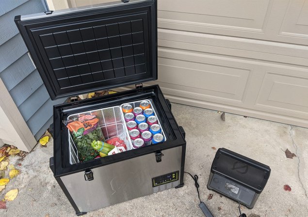 open electric cooler with produce and cans inside next to a portable power station