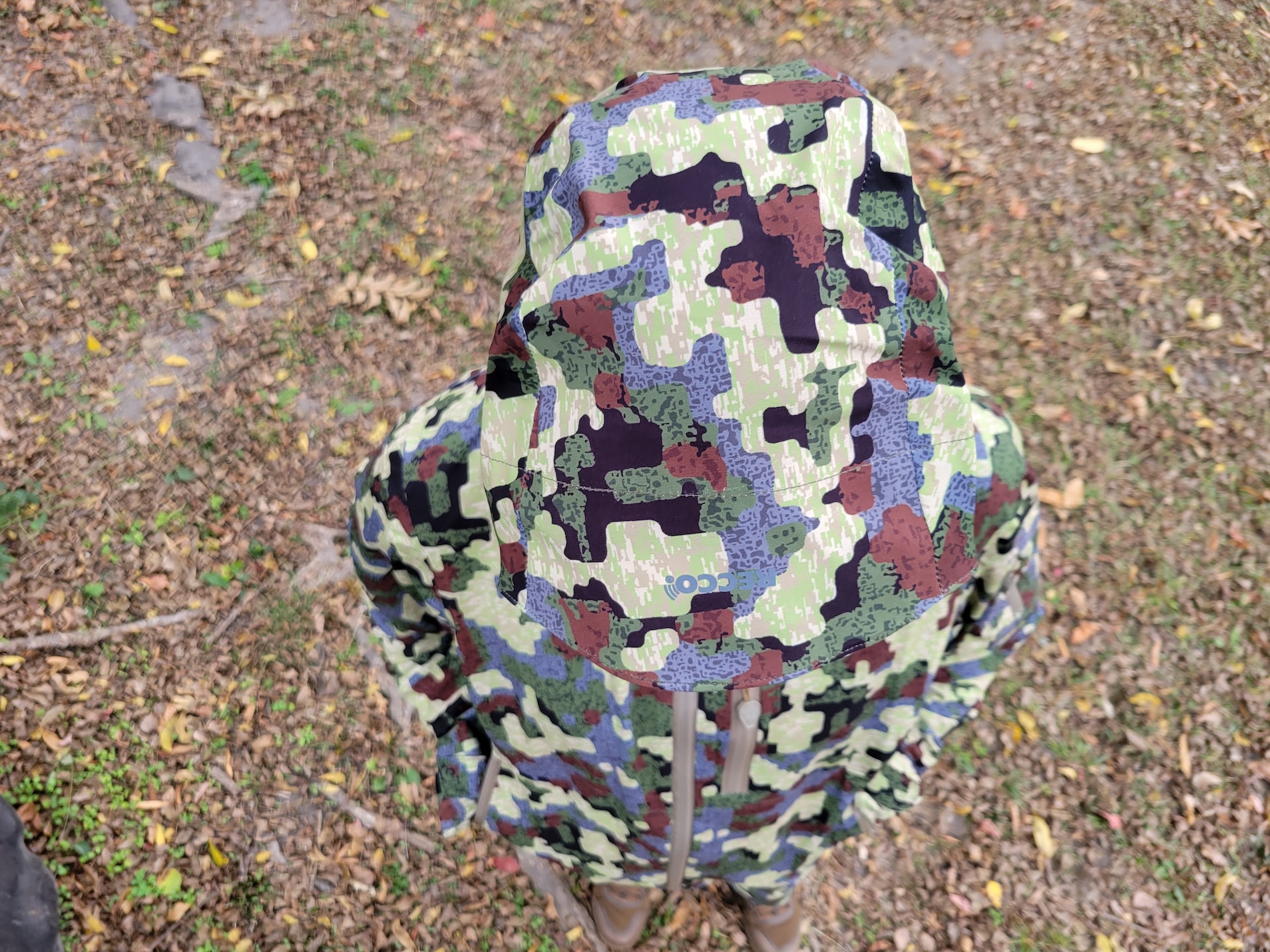 An overhead view of a camouflage rain coat.