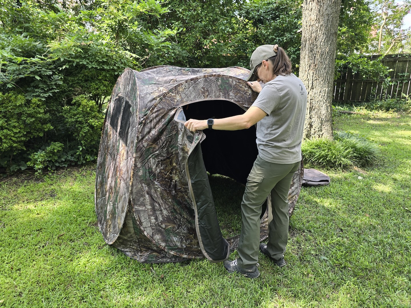 A woman opens the door of a pop-up hunting blind.