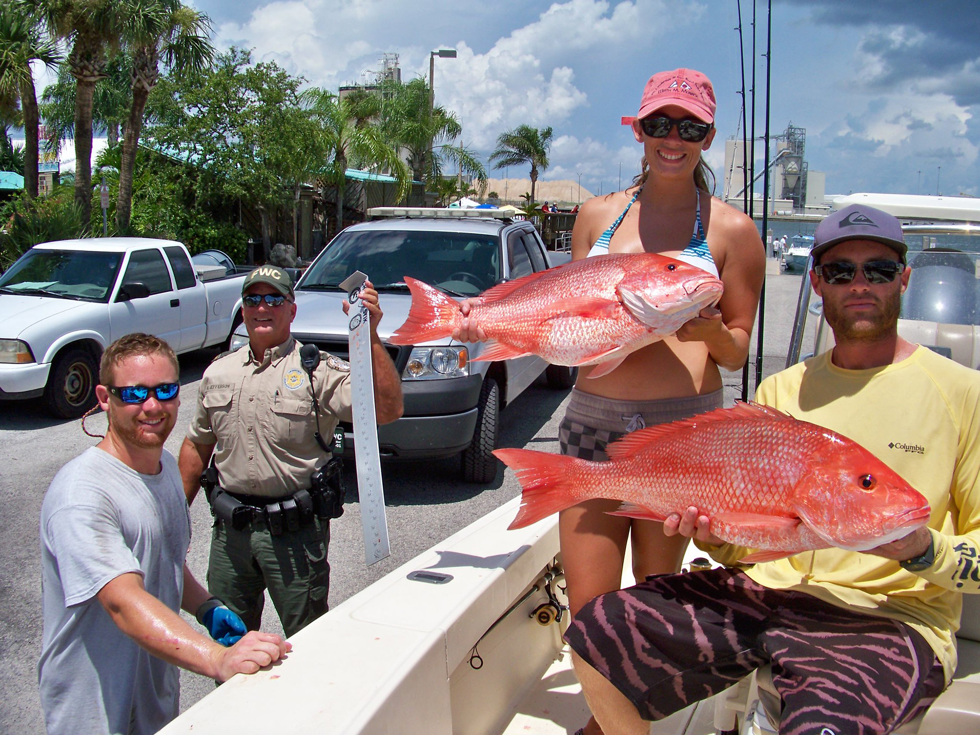 Two anglers hold up red snappers.