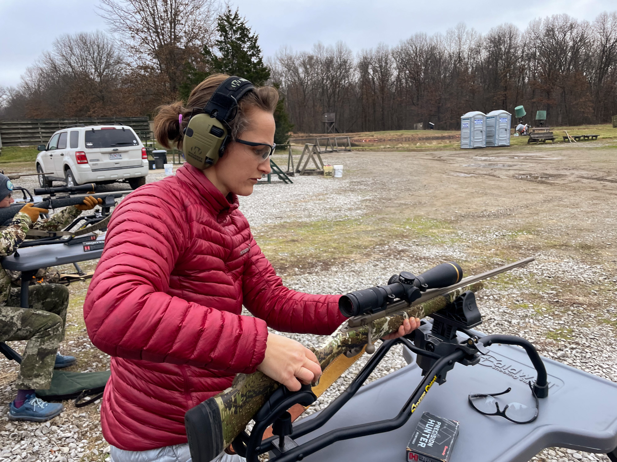 A hunter lifts a rifle.