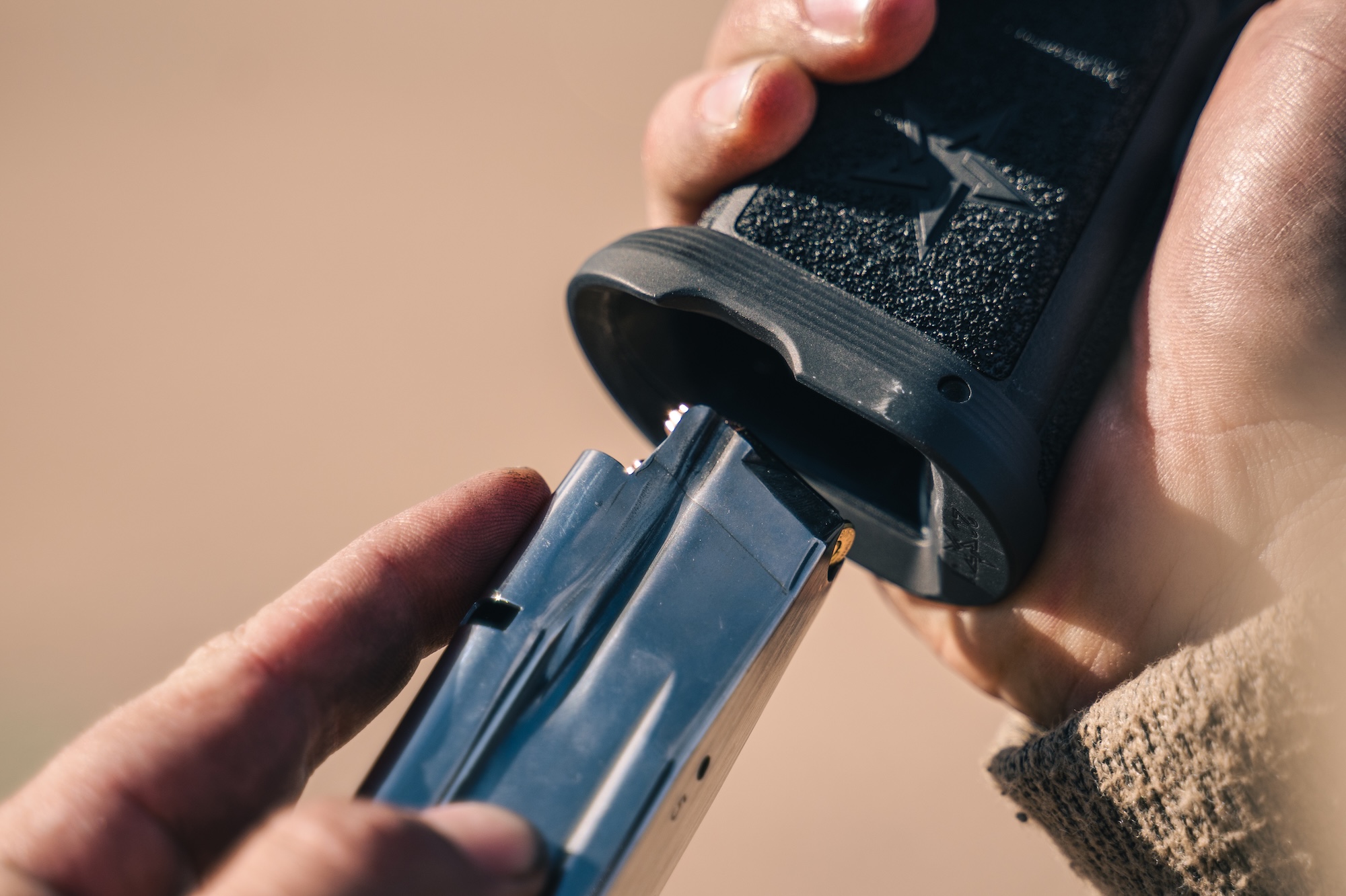 Loading a handgun with a magazine.