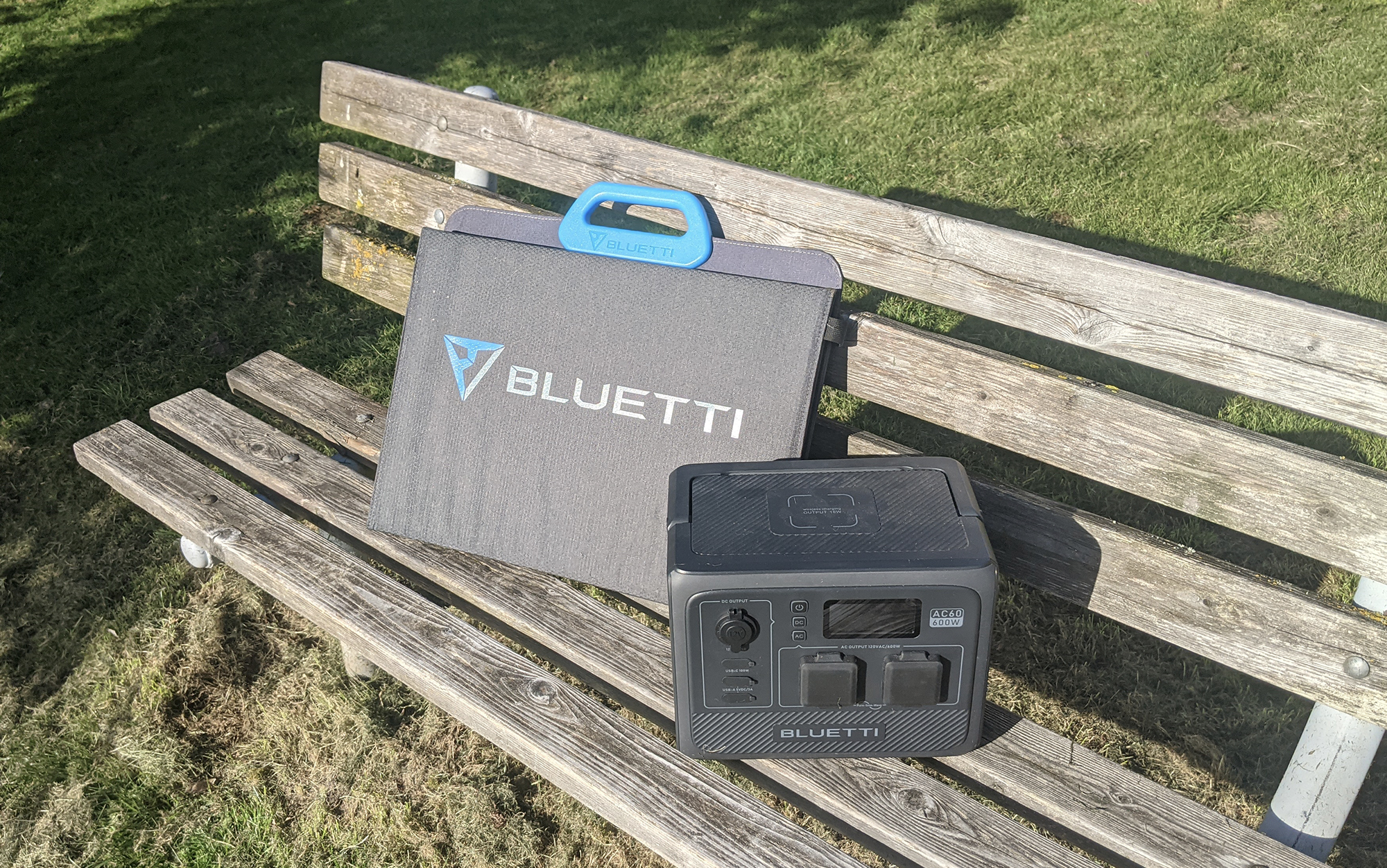 a small power station and a solar panel sit on a wooden bench