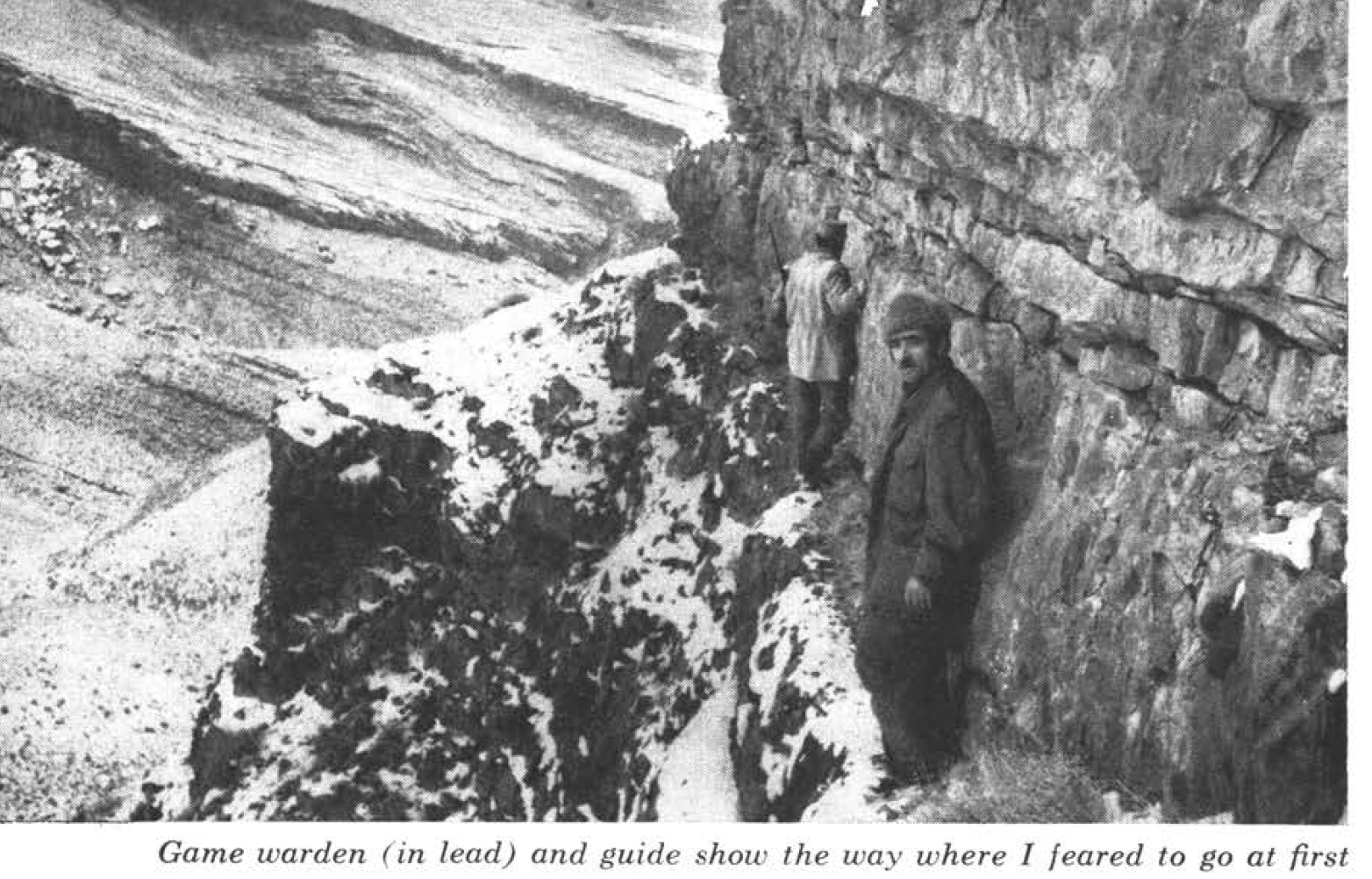 Two hunters sidle along a steep cliff.